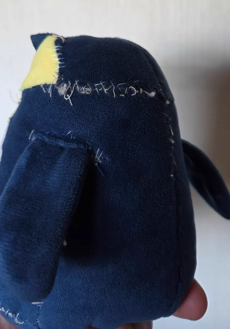 子どもが遊んで縫い目がほつれてきたペンギンの背面